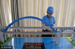 2017年6月28日，四川省宜宾市，工作人员查看宜宾金沙江公铁两用桥沙盘模型。28日，随着主拱最后一段拱肋吊装到位，成都至贵阳铁路的控制性工程——宜宾金沙江公铁两用大桥主拱合龙，标志着成贵铁路建设取得重大阶段性胜利。成贵铁路金沙江公铁两用桥全长1603米，主跨336米，采用公铁合建方案跨越金沙江。成都商报记者 王勤 摄影